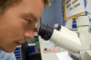 scienziato osserva al microscopio